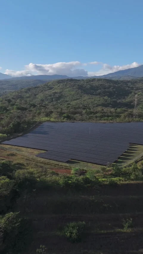 Drone Rising Over Small Hydroelectric Plant into Solar Panel Array Stock Footage 320537985