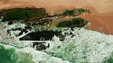 Drone  is rising over the surface of the water along the rocky shore Stock Footage 197558100