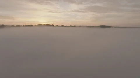 Drone rising shot through clouds revealing sunrise over clouds and fields  Stock Footage 301316648