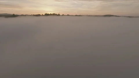 Drone rising shot through clouds revealing sunrise over clouds and fields  Stock Footage 301316702