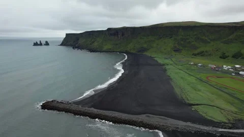 Drone rotate over black sand beach with Reynisdrangar sea stacks, Vik Iceland Stock Footage 346552416