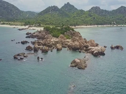 Drone Rotates around Shore Plot Washed by Ocean against Hills Stock Footage 80074947