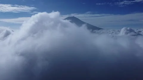 The drone rotates around white clouds near the mountain Video stock 277495234