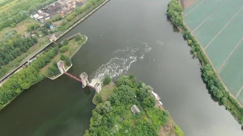 Drone rotating downward above river and dam Stockbeeldmateriaal 324756765