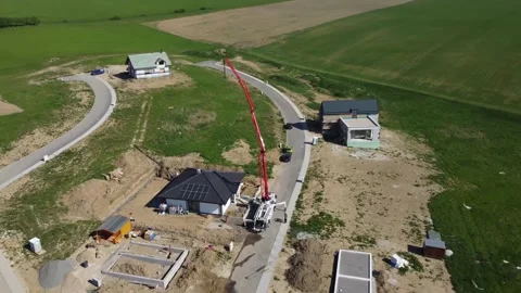 Drone rotating over concrete pump and crane over a new house building in small w Stock Footage 218116658