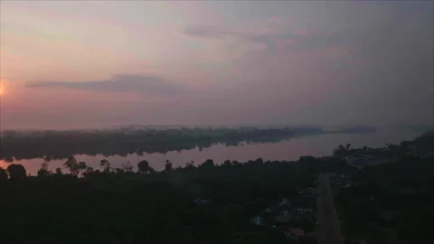 Drone rotating revealing sun with forest and river, Ouesso, Congo Stock Footage 331999900