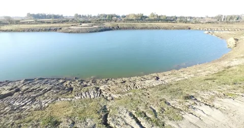Drone scene going fast parallel to earth. From lake to machines. Stock-Footage 52090365