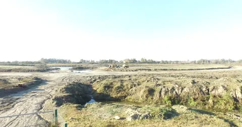 Drone scene going fast parallel to earth. From construction machines to lake. Vidéo 52090699