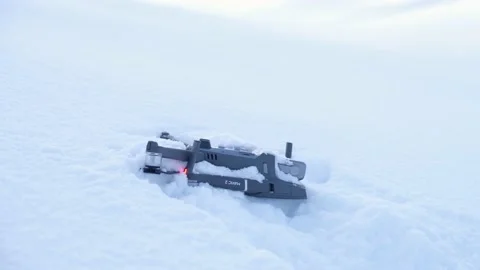 Drone is seen laying in the snow after a crash high up on a mountain 스톡 동영상 171544562