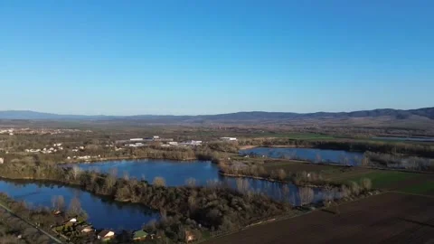 Drone semi-orbit over lake with city &amp; mountains Video stock 331821404
