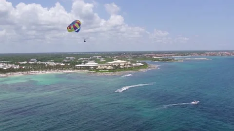 DRONE SHOOT OF BEACH PARACHUTE OVER BLUE SEA AT RIVIERA MAYA Video stock 229693411