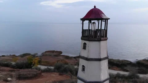 Drone shooting a close-up of a lighthouse on a hill by the sea and a group of Stock-Footage 152467736