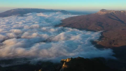 Drone shooting over the peak of Mount Demerdzhi and fly high above the clouds Video stock 168282467