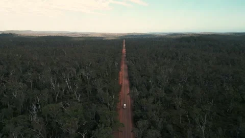 Drone shot above a van driving on a australian red dirt road through the Stock Footage 259969689