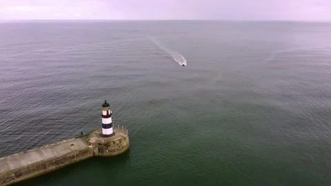 Drone shot accelerating over Seaham Harbour, boat and lighthouse, 4k Stock Footage 172169797