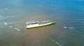 Drone shot aerial abandoned ship wreck at flat water coast in Flores - Indonesia Photo