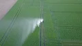 Drone shot aerial irrigation traveling sprinkler on green field with tracks 4k or 4k+ Resolution