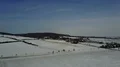 Drone shot aerial street in snowy farmland winter landscape low mountain range 4k or 4k+ Resolution