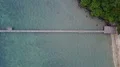 Drone shot aerial top view follow quay at tropic sand beach with trees 4k or 4k+ Resolution