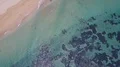 Drone shot aerial top view flyover low tide sea water coastline reef to beach 4k or 4k+ Resolution