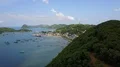 Drone shot aerial tropic beach and forest mountain in front of village harbor 4k or 4k+ Resolution