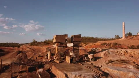 Drone shot aerial view post-apocalyptic desert mining ruins by a lake Stock Footage 159512990