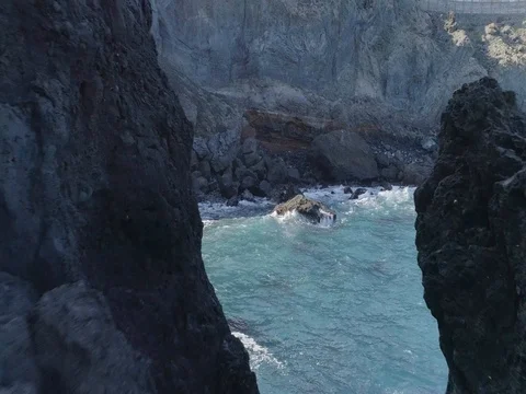 Drone shot of alone rock surrounded by powerful oceanic waves Stock Footage 83870580
