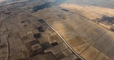 Drone shot of an asphalt road surrounded by many empty fields. Stock Footage 145694222
