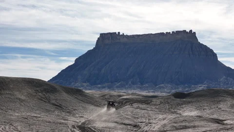 Drone Shot of ATV Vehicle Making Dust on the Way to Factory Butte, Utah USA Stock Footage 345400509
