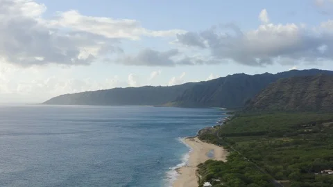 Drone shot of bay with deep blue sea, green cliffs and yellow sand beach, Hawaii Stock Footage 126600526