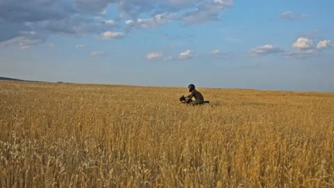 Drone shot of a bearded man riding an old cafe racer motorcycle in wheat field Stock Footage 140362618