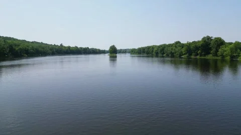 Drone Shot of Blue River with Trees Along Shoreline with Green Forest Landscape Stock Footage 244958946