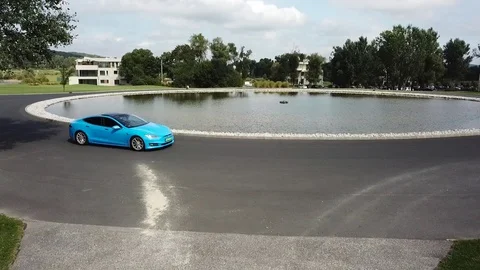 A drone shot of a blue tesla 動画素材 115991835