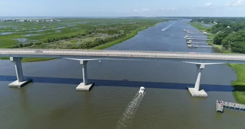 Drone shot of boat going under Sunset Beach Bridge on the Intercoastal Waterway  Stock Footage 202344287