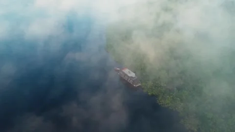Drone Shot of Boat Resting on Amazon River Margin With Mist Stock Footage 322114732
