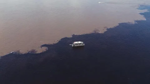 Drone shot of boat sailing between dark and brown rivers at the Amazon Stock Footage 322114684