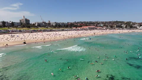 Drone shot of Bondi Beach, showcasing people surfing, sunbathing, and relaxing Stock Footage 301060548