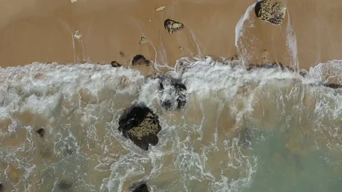 Drone Shot Of Breaking Waves On Wide Sandy Beach In The Middle Of The Cliff Stock Footage 128836423