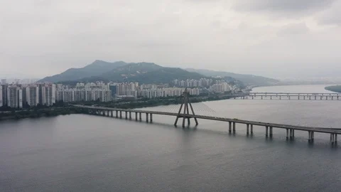 Drone shot of bridge over river in Seoul with skyscrapers by shore Stock Footage 126613282