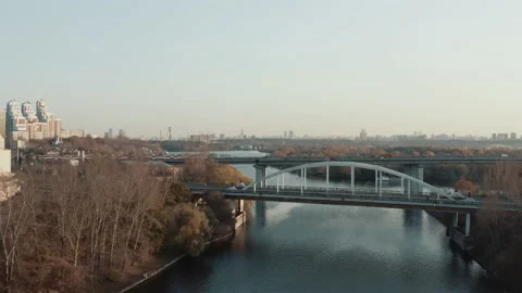 Drone shot of a bridge over the river, forest trees in autumn Video stock 144382963