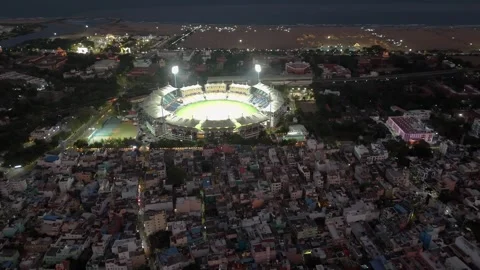 Drone shot of a brightly lit cricket stadium with Marina Beach in the Stock Footage 332454857