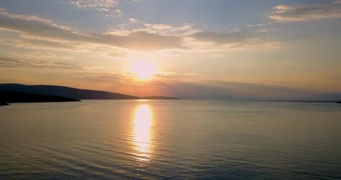Drone shot of bronze colored sunset over seascape Stock Footage 107956223