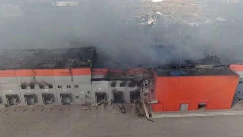 Drone shot of burnt down warehouse with smoke clouds. Stock Footage 210106792