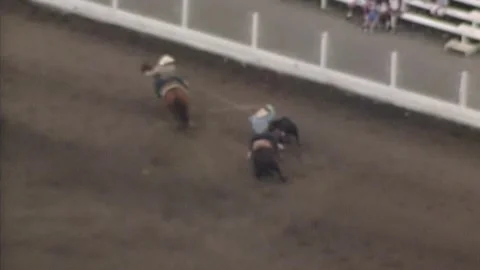 DRONE SHOT OF A CALF ROPING AT A RODEO BY COWBOYS Stock Footage 296423778
