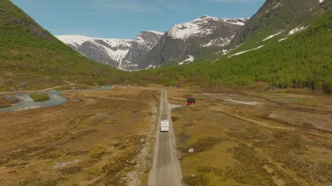 Drone Shot Camper Driving in Austerdalsbreen Valley Norway with Snowcapped Vidéo 334668731