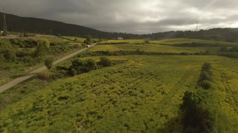 Drone shot of a camper van driving on a road between meadows. Stock Footage 274476400