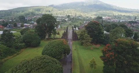 Drone shot of Candi Bentar split gates on roadside amidst trees in town Stock Footage 96228419
