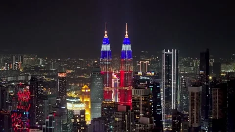 Drone shot captures KLCC twin towers glowing above Kuala Lumpur skyline Video stock 332087870