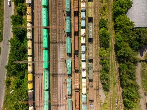 Drone shot captures rows with green yellow blue vehicles on steel tracks amon Fotos Stock