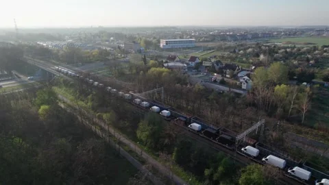 A drone-shot captures two freight trains passing through the city in the mo.. Video stock 240927416